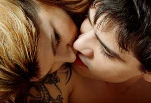 Kvinde og mand kysser, mens manden er permanent mærket med en tatovering